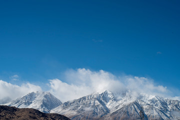 clouds and fresh fallen show on Eastern Sierra Nevadas, California, USA 
