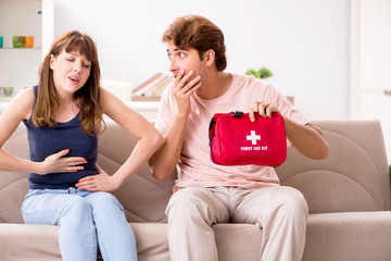 Obraz premium Young family getting treatment with first aid kit