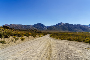 Endless dirt road with mountains background