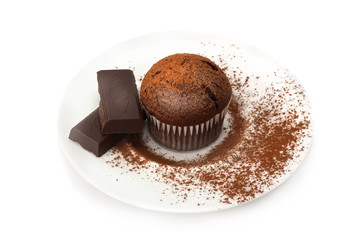 Chocolate muffin on a saucer in the cocoa powder .