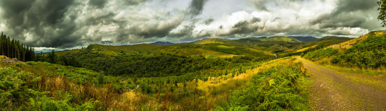 Scenic Landscape With Green Valley And Cloudy Sky In Scotland