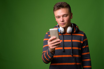 Studio shot of young handsome man against green background