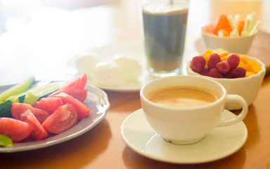 Breakfast with coffee, egg, vegetables and fruits