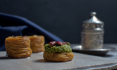 Turkish coffee with delight and traditional copper serving set on wooden background. Assorted traditional turkish dilight or lokum and turkish coffee in metal traditional cups.Copy space.Selective foc