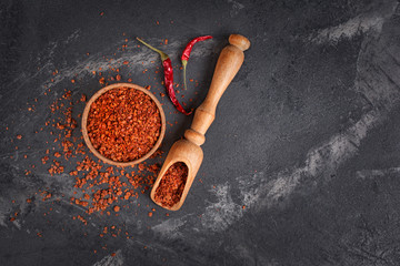 Top view of dry red chili pepper in wooden bowl and scoop