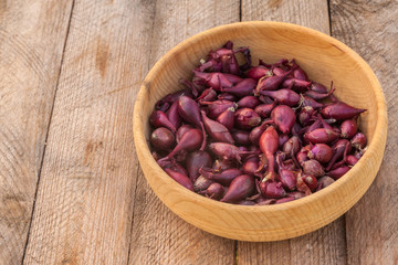 Wooden bowl with a small onion for planting