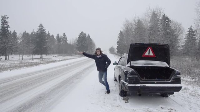 The guy asked for assistance, the car broke down on the road in winter. Trying to stop a passing car.