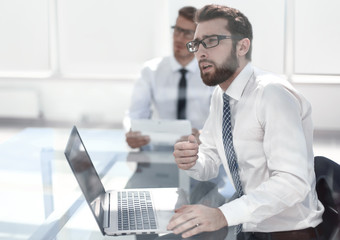 thoughtful employee sitting at the office Desk