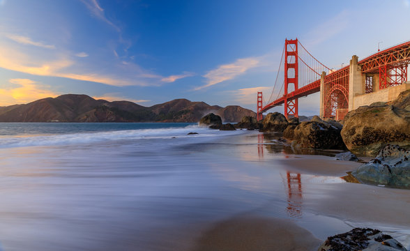 Golden Gate Bridge view from the hidden and secluded rocky Marshall's Beach at sunset in San Francisco, California