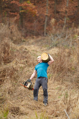 Strong lumberjack carrying log on shoulder