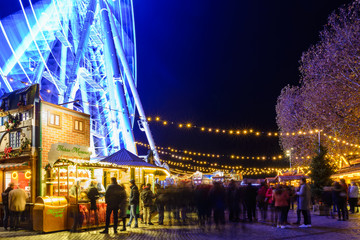 Night colorful atmosphere of Weihnachtsmarkt, Christmas market, in Düsseldorf, the ferris wheel...