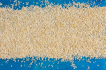 Grains of quinoa on a blue wooden backgound with space for text