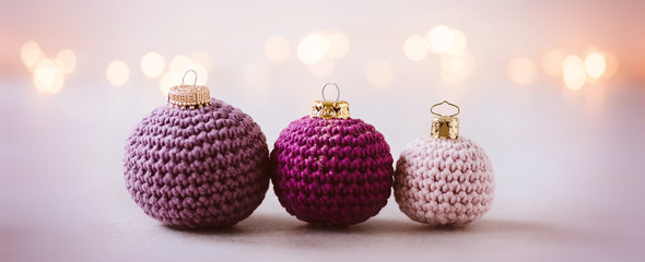 Wollige Weihnachtsgrüße - gehäkelte Weihnachtskugeln als Weihnachtsdekoration, romantisch und feminin mit Lichterbokeh im Hintergrund,  Banner-Format