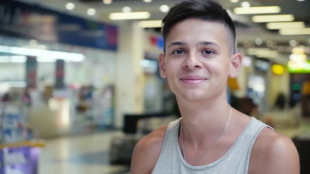 Happy teenager in a sleeveless singlet standing in a supermarket in Ukraine