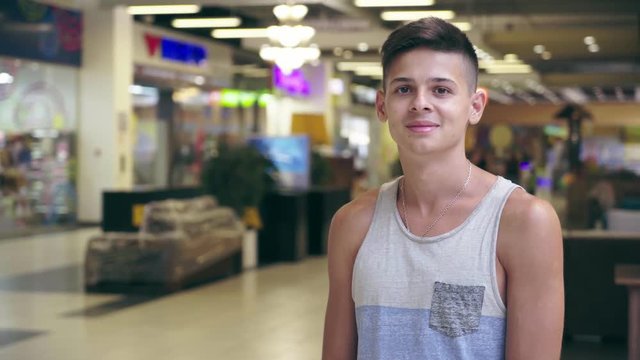Cheery young man in a sleeveless singlet standing in a supermarket in Ukraine