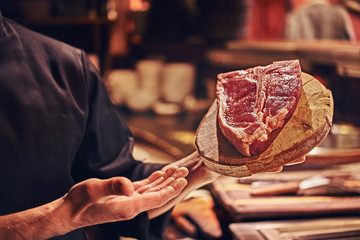 Close-up image of a fresh steak on a wooden cutting board