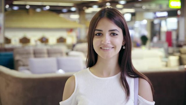Pretty young woman smiling in a city mall with a cafeteria in Ukraine