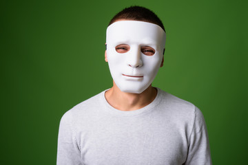 Studio shot of young handsome man against green background