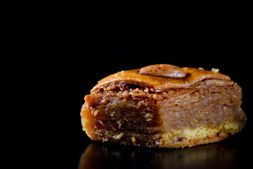Middle Eastern dessert called mabroume or bahlava isolated on black background.