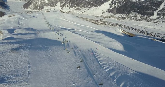 4k, aerial footage, drone following near skiers on ski slope in skiing region, Italy, Livigno Italian Alps