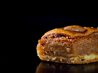 Middle Eastern dessert called mabroume or bahlava isolated on black background.