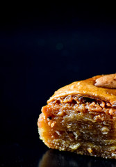 Middle Eastern dessert called mabroume or bahlava isolated on black background.