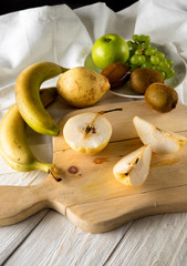Ingredients for fruit salad. Cutting pears on a cutting board