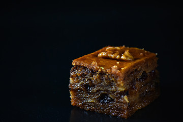 Middle Eastern dessert called mabroume or bahlava isolated on black background.
