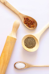 RODILLO Y CUCHARAS DE MADERA CON ESPECIAS SOBRE FONDO BLANCO