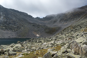 Amazing panorama of Ledenoto (Ice) Lake and clouds over Musala Peak, Rila mountain, Bulgaria