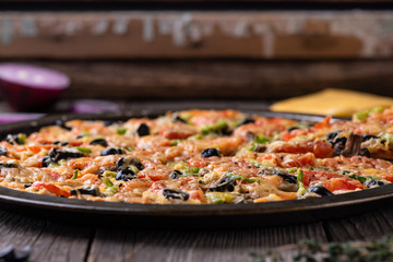 Fragrant pizza fresh from the oven, on the old wooden table