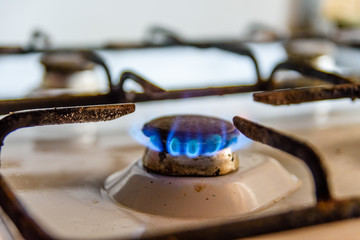 Gas burner on the white kitchen stove