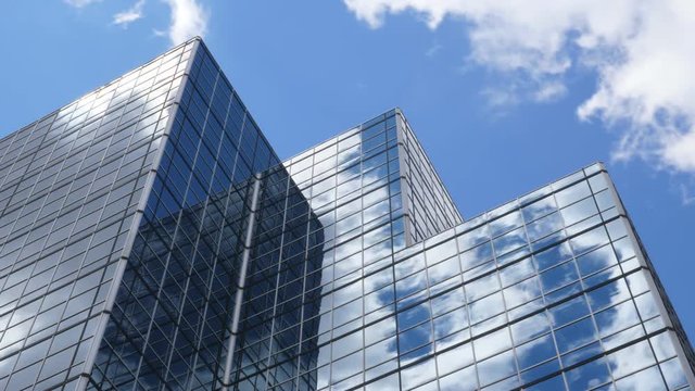 Office building with blue sky and clouds moving past. Time lapse.