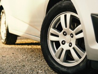 Close-up car tire and rim. used, obsolete car tire and car side view