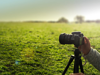 photographer taking landscape photo with dslr camera on tripod