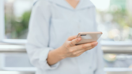 woman using smartphone on staircase in public areas, During leisure time. The concept of using the phone is essential in everyday life.