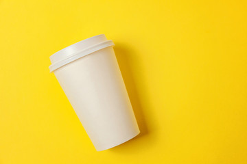 Simply flat lay design paper coffee cup on yellow colorful trendy background. Takeaway drink container. Good morning wake up awake concept. Template of drink mockup. Top view copy space