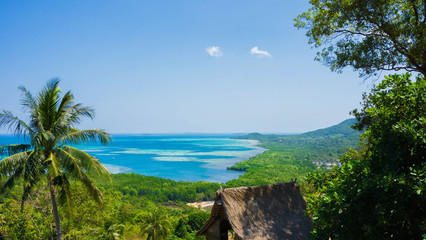 mountain view with stone and green tree forest and blue sea water in distance in karimun jawa