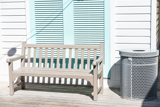 Pastel turquoise blue colorful hurricane window shutters closeup of wooden bench architecture in Florida beach sidewalk during sunny day, painted
