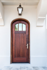 Closeup of house wall luxury modern wooden door white architecture, lamp lantern hanging on...