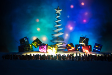 New year or Christmas holiday shopping concept. Store promotions. Silhouette of a large crowd of people watching at a big shopping trolley with gifts. People on snow prepares to shopping.