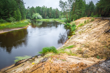 Fototapeta na wymiar Indistinct coast with current fast river in Siberian taiga of wood.