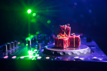 Dj mixer with headphones on dark nightclub background with Christmas tree New Year Eve. Close up...