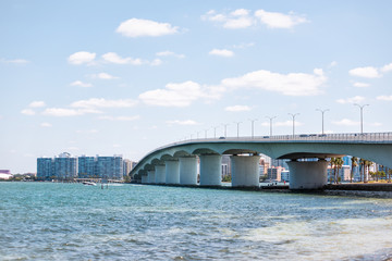 Sarasota, USA Beach in Florida city during sunny day, cityscape, bay, buildings, and John Ringling causeway bridge