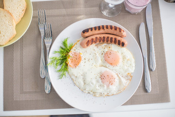 Traditional breakfast with  sausages, fried eggs, bread and yogurt
