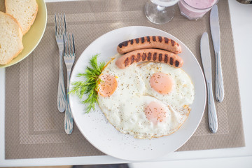 Traditional breakfast with  sausages, fried eggs, bread and yogurt
