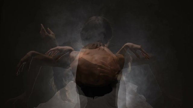 modern ballet dancer posing on dark background with smoke