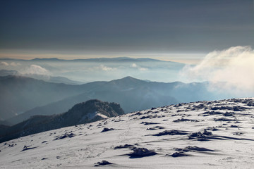 Snow formations on barren windy slope of Krizna peak in Velka Fatra range with silhouettes of Stare Hory and Polana Mountains in morning haze, Carpathians Banska Bystrica Region Slovakia Europe © nogreenabove2k