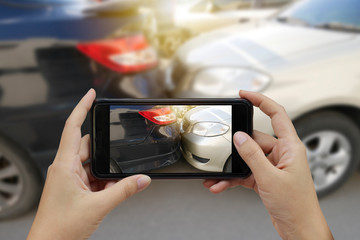 Close up hand holding smartphone and take photo at The scene of a car crash