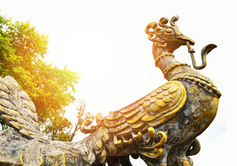 Golden peacock pheasant statue in the garden park